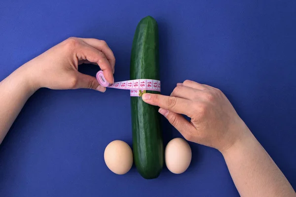 Cucumber Eggs Blue Background Woman Hands Measure Width Penis Concept — Zdjęcie stockowe
