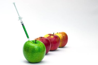 Yeşil bir elmaya şırınga enjeksiyonu. Genetik modifiye yiyecekler, GMO. beyaz arkaplanda izole.