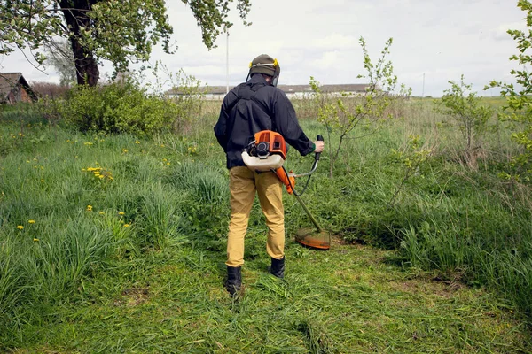 Trädgårdsmästaren Klipper Gräset Med Gula Maskrosor Med Handgräsklippare Närbild Händer — Stockfoto