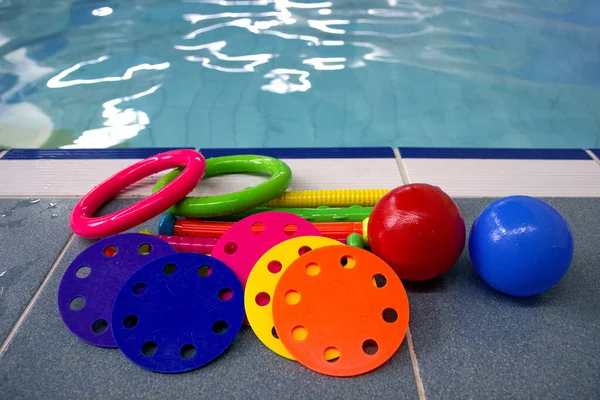 Wielokolorowe Zabawki Pływania Nurkowania Treningowe Leżą Stronie Basenu — Zdjęcie stockowe