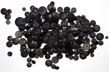 Arka planda düğme dikiyorum. Siyah dikiş düğmeleri dokusu ve beyaz arkaplandaki desenler