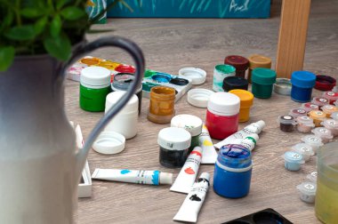 Suluboya boya seti, guaj, yerdeki boya fırçaları. Sanatçının yaratıcılık ve resim sürecindeki atölyesi