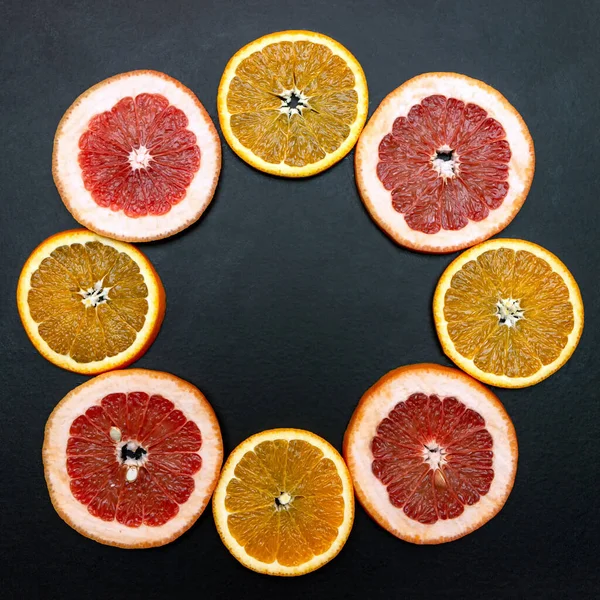 assorted of slice citrus and grapefruit fruits on black background with copy space