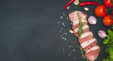 Çiğ, sulu biftekler siyah tebeşir tahtasında kızartılmaya hazır. Kiraz domatesli fileto, acı biber ve bitki. Metin, deri döşeme, pankart için boşluk