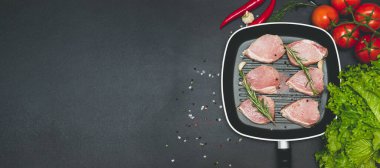 Çiğ, sulu biftekler siyah tebeşir tabağında kızartılmaya hazır. Domatesli fileto, acı biber ve bitki. Metin, pankart, düz uzanma için boşluk