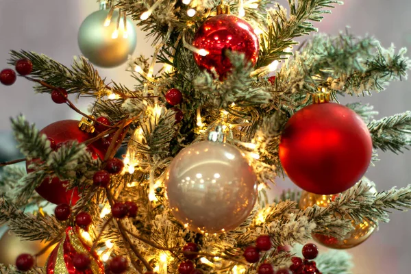 Decorado árvore de Natal closeup fundo. Bolas vermelhas e prateadas e guirlanda iluminada com lanternas. Ano Novo bugigangas foto macro com bokeh. Inverno decoração de férias — Fotografia de Stock