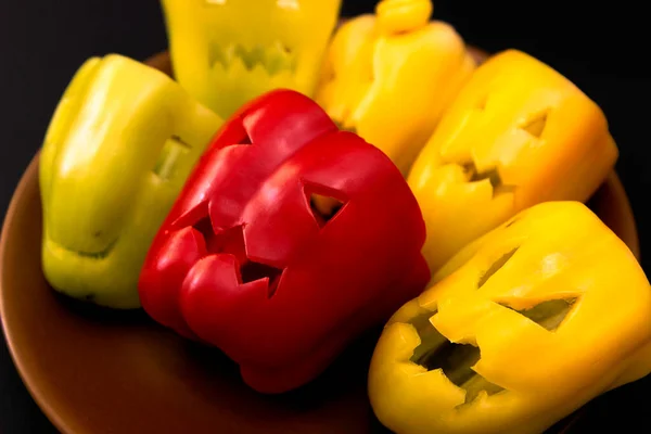 Kolorowe Papryki Halloween Wyciąć Różne Twarze Talerzu Czarnym Tle Zbliżenie — Zdjęcie stockowe