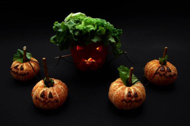 Patron çalışanı, çalışanlarını iş konseptinde manipüle ediyor. Cadılar Bayramı biberleri ve seçici odaklı mandalinalar.