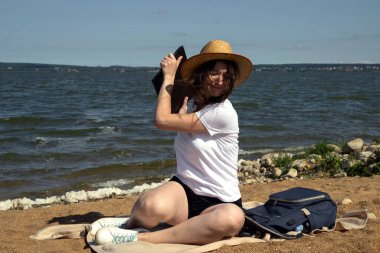 Kadın deniz kenarında çalışıyor ve bir dizüstü bilgisayar atmak istiyor. Serbest çalışan kadın sinirli, sinirli, üzgün. İşle ilgili sorun