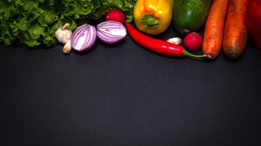 Çiğ organik sebzeler. Sağlıklı bir şekilde pişirmek için taze malzemeler. Koyu kaliteli arka planda. Vegan ya da diyet gıda konsepti. Boş metin alanı olan arkaplan düzeni.
