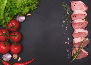 Çiğ, sulu biftekler siyah tebeşir tahtasında kızartılmaya hazır. Kiraz domatesli fileto, acı biber ve bitki. Metin için boşluk, deri döşeme