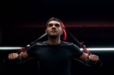 Vücut geliştirici TRX ile GYM 'de egzersiz yapıyor.