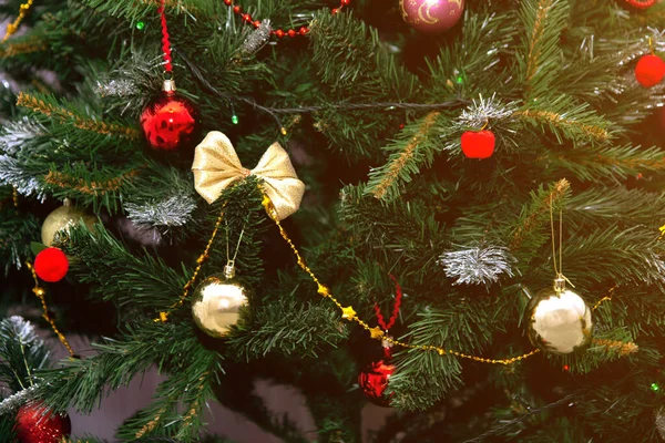 Decorato albero di Natale primo piano sfondo. Palle rosse e argentate e ghirlanda illuminata con torce. Capodanno bagattelle macro foto con bokeh. Decorazione vacanze invernali — Foto Stock