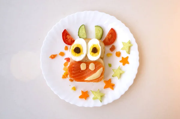 Sanduíche engraçado com símbolo comestível de 2021 vaca de touro feita de pão torrado, peixe vermelho, queijo, passas, ovos e legumes. Ideia de pequeno-almoço para crianças. comida de natal vista superior, arte alimentar. — Fotografia de Stock