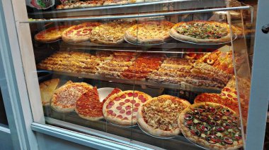 dolu bir pizzacı, vitrin ve pişmiş doldurulmuş pizza, yuvarlak, büyük, tüm renklerin