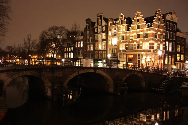 Beroemde brug in amsterdam. romantische nacht landschap. een beetje nevel en mist maakt het magische kanaal — Stockfoto