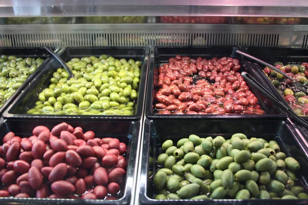 Azeitonas domésticas. quatro tipos diferentes, verde claro, escuro, vermelho, exposto ao mercado para a venda de pessoas gananciosas — Fotografia de Stock