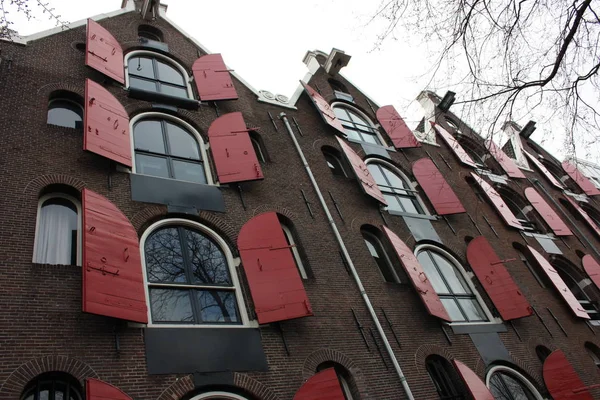 Amsterdam, windows in row with opened red shutters, shooting from below in historical building — Stock Photo, Image