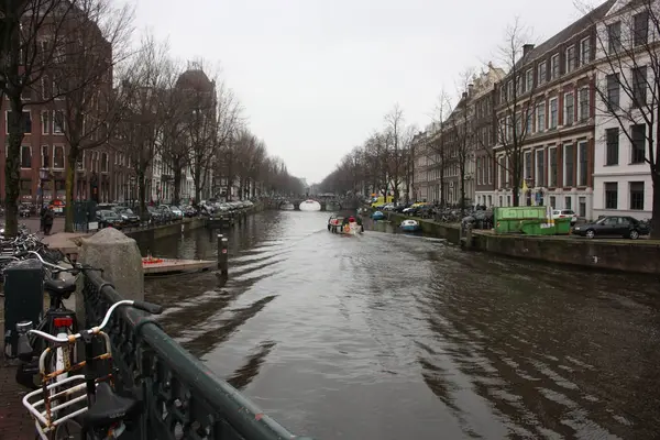 Brzy na jaře scéna v Amsterdam city. Výlety lodí na slavné holandské kanály. Panoráma města s domy kanálu v Holandsku, Nizozemsko — Stock fotografie