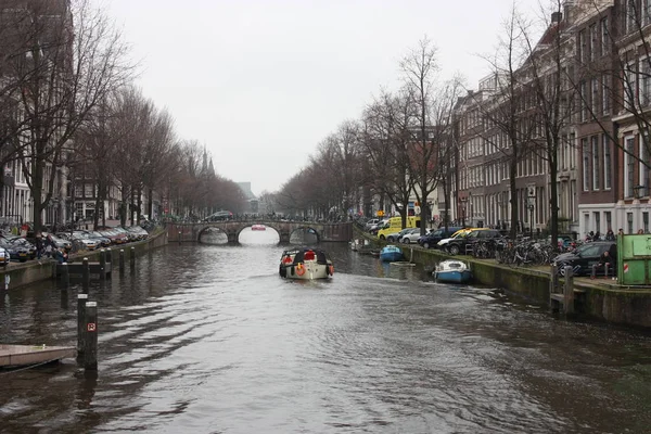 Brzy na jaře scéna v Amsterdam city. Výlety lodí na slavné holandské kanály. Panoráma města s domy kanálu v Holandsku, Nizozemsko — Stock fotografie