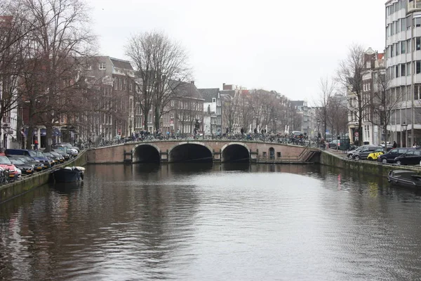 Brzy na jaře scéna v Amsterdam city. Výlety lodí na slavné holandské kanály. Panoráma města s domy kanálu v Holandsku, Nizozemsko — Stock fotografie