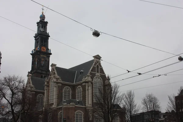 Tall Dutch buildings built in red bricks in the style of Amsterdam. cold autumn day, gray and cloudy — Stock Photo, Image