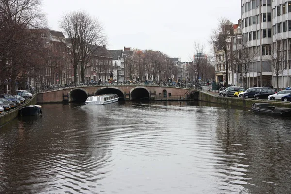 Brzy na jaře scéna v Amsterdam city. Výlety lodí na slavné holandské kanály. Panoráma města s domy kanálu v Holandsku, Nizozemsko — Stock fotografie