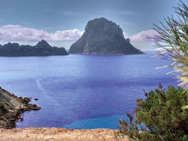 Ibiza y sus maravillas. el mar azul cristalino, el islote de Es Vedra visto desde los acantilados de Cala D 'Hort en un día turístico azul de verano — Foto de Stock