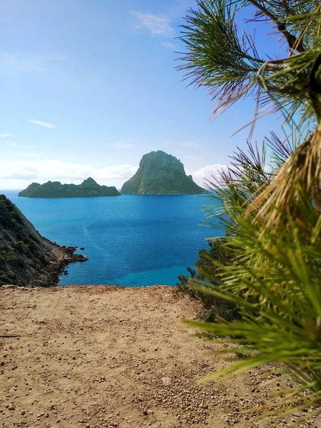 Ibiza e le sue meraviglie. il mare cristallino, l'isolotto di Es Vedra visto dalle scogliere di Cala D'Hort in una blu giornata turistica estiva — Foto Stock