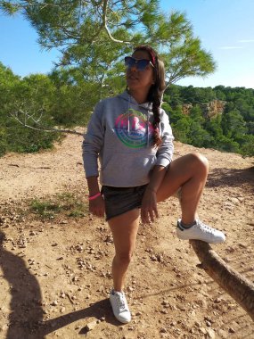 gri sweatshirt kızla doğa ağaçlar ve arazi Cala d'Hort Ibiza ve onun parlak renkler arasında sahiptir