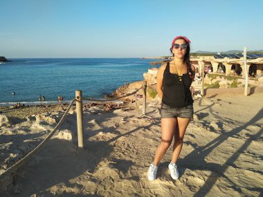 şort ve tank top esmer beyaz kız. kişi Cala Comte Ibizan günbatımı sahiptir