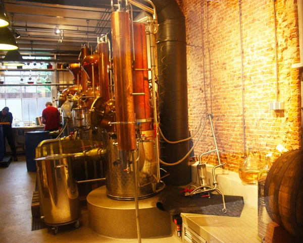 Oranje verlichting in een interieur kamer van een distilleerderij. materialen voor de productie van likeuren werken. industrie en machines — Stockfoto