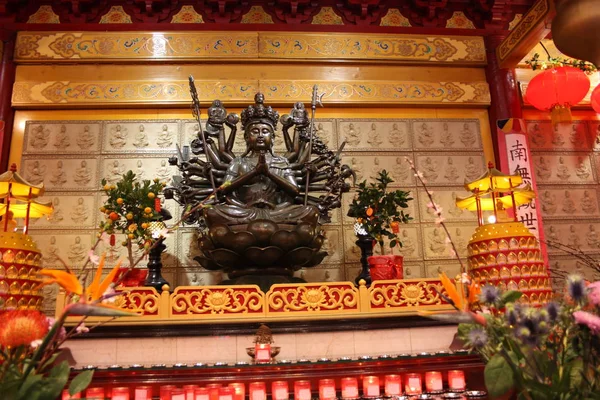 Ένα αόριστο ιερή θρησκευτικό άγαλμα του ένας κινεζικός βουδιστικός ναός. Φωτεινά χρώματα και πορτοκαλί φόντο. — Φωτογραφία Αρχείου