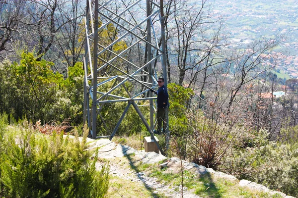 Caucásico chico de pie bajo un pilón eléctrico de alto voltaje — Foto de Stock