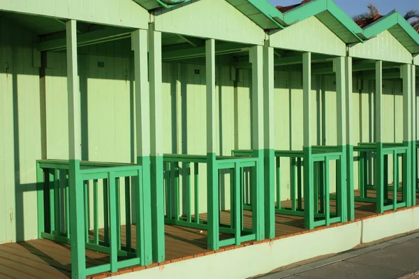 Badehütten am Meer in grüner Farbe. Buden zum Umziehen während der Sommersaison in den Strandferien. Umkleidekabinen in einer regelmäßigen und geordneten Reihe angeordnet — Stockfoto