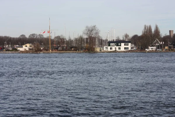 Amsterdam merkez istasyonu önünde kanal veya nehir, banliyö ve turistler için toplu taşıma olarak kullanılan — Stok fotoğraf