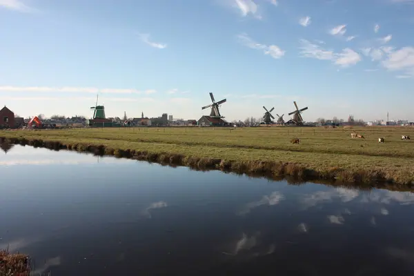 Viaje turístico a Zaanse schans en un día soleado, entre los típicos y característicos molinos de viento de Holanda y sus vías fluviales — Foto de Stock