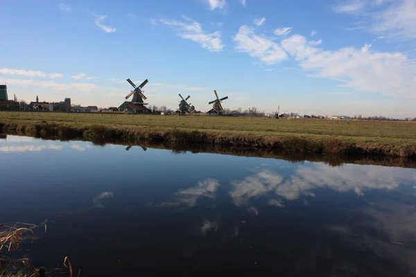 Viaje turístico a Zaanse schans en un día soleado, entre los típicos y característicos molinos de viento de Holanda y sus vías fluviales — Foto de Stock