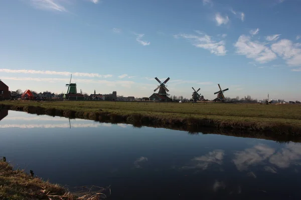 Viaje turístico a Zaanse schans en un día soleado, entre los típicos y característicos molinos de viento de Holanda y sus vías fluviales — Foto de Stock