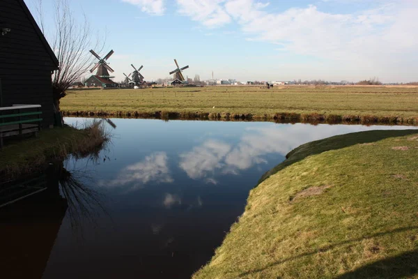 Viaje turístico a Zaanse schans en un día soleado, entre los típicos y característicos molinos de viento de Holanda y sus vías fluviales — Foto de Stock