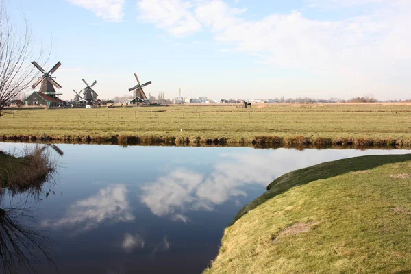 Viaje turístico a Zaanse schans en un día soleado, entre los típicos y característicos molinos de viento de Holanda y sus vías fluviales — Foto de Stock