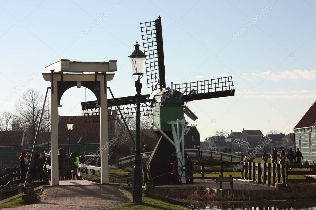 spring trip to Zaanse Schans. Placid channels, tranquil rivers flow between the hills. The Dutch windmills stand as a traditional tourist landmark after centuries