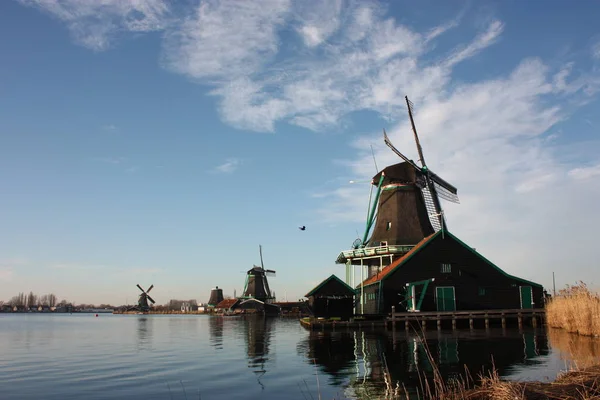 Velho moinho de vento de madeira holandês em zaanse schans na água do rio Zaan — Fotografia de Stock