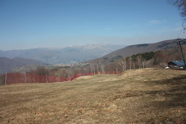Campos verdes. pistas de esquí vistas en verano para cuidar. camino pavimentado y verde sin nieve, tierra seca y árida en Toscana — Foto de Stock