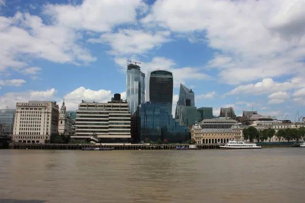 Een wolkenkrabber met vreemd gevormde spiegels stijgt over de Thames River — Stockfoto