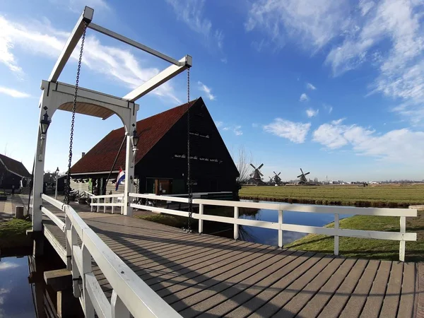 De Nederlandse buitenwijk van Zaansche Schans. De waterkanalen, het serene klimaat en de typische windmolens. — Stockfoto