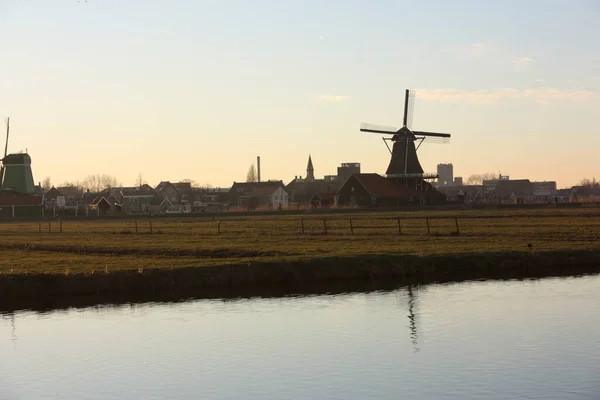 Romantisk solnedgång i röda och gula färger. slätten på landsbygden av zaanse schans med sina typiska nederländska fabriker — Stockfoto