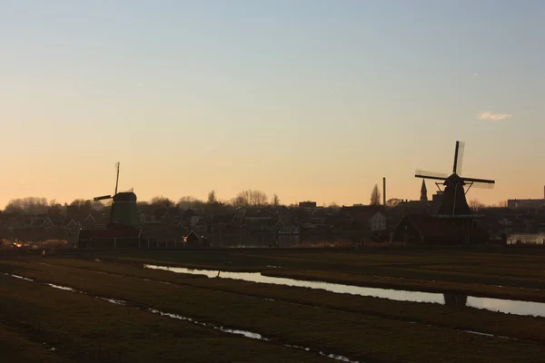 Romántico atardecer en colores rojo y amarillo. la llanura del campo rural de zaanse schans con sus típicos molinos holandeses — Foto de Stock