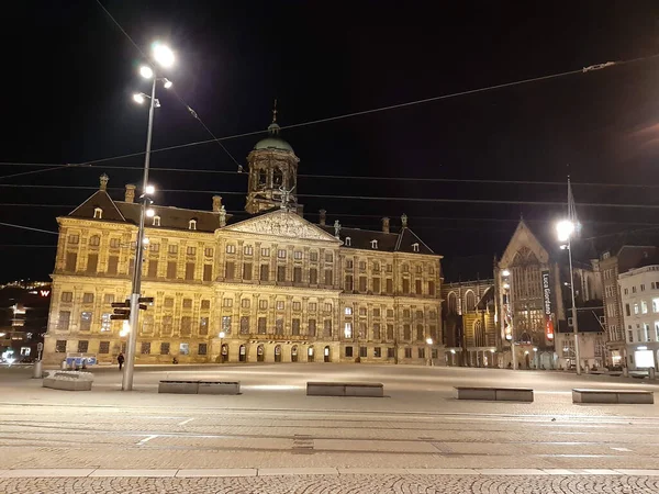 夜のアムステルダムのダム広場には オランダの街路や建物がライトアップされています — ストック写真