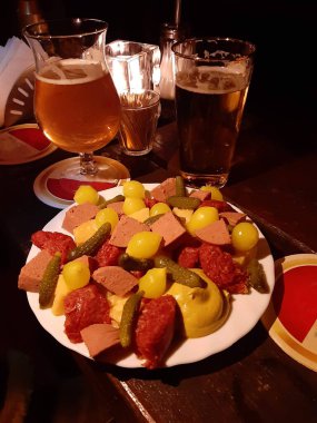 Taze kırmızı birayla sade Hollanda aperatifi turşu, soğan, sosis ve hardal turşusuyla birlikte aperatifler.